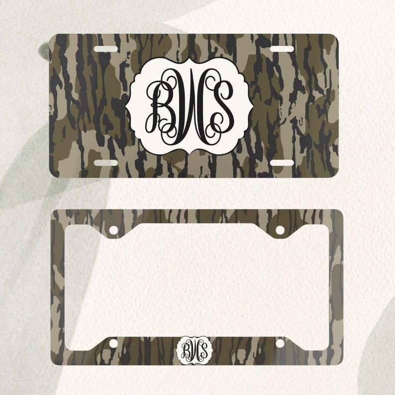 Op de afbeelding: Een kentekenplaat en frame set met een camouflagepatroon in bruin, beige en zwart. De kentekenplaat heeft een wit embleem met de zwarte initialen "BVS". De bijpassende lijst heeft hetzelfde camouflagepatroon en de initialen.