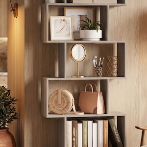 May include: A contemporary grey, asymmetrical bookcase displaying decorative items. It includes potted plants, framed art, a mirror, a handbag, books, and a woven basket. The shelves are set against a wood-panelled wall, offering a stylish storage solution.