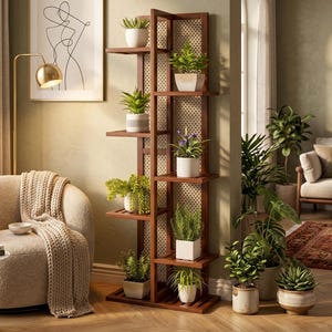 Op de afbeelding: Een hoge, donkerbruine houten plantenstandaard met meerdere planken, waarop diverse potplanten staan. De standaard heeft een roosterachtige achterkant en staat in een lichte kamer met een neutraal kleurenpalet. De planten omvatten vetplanten en bloeiende soorten.