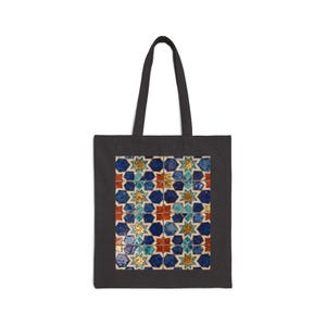 Peut inclure: Sac fourre-tout noir avec un motif géométrique coloré d'étoiles et d'hexagones bleus, rouges et dorés. Le motif rappelle les carreaux traditionnels. Le sac a une forme simple et rectangulaire avec une poignée.
