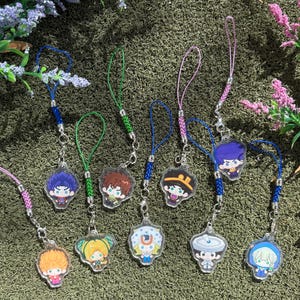 Puede incluir: Una colección de nueve dijes de acrílico transparente con coloridas ilustraciones de personajes estilo anime. Cada dije está sujeto a un pequeño broche de langosta de metal y a un lazo de cordón de nailon trenzado en varios colores.