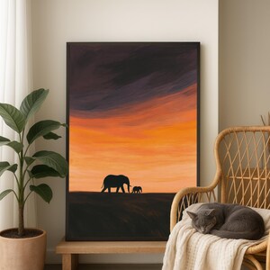 May include: A framed art print depicts a silhouette of two elephants against a vibrant sunset. The sky transitions from dark purple to fiery orange. The artwork is displayed on a wooden bench, next to a potted plant and a wicker chair.