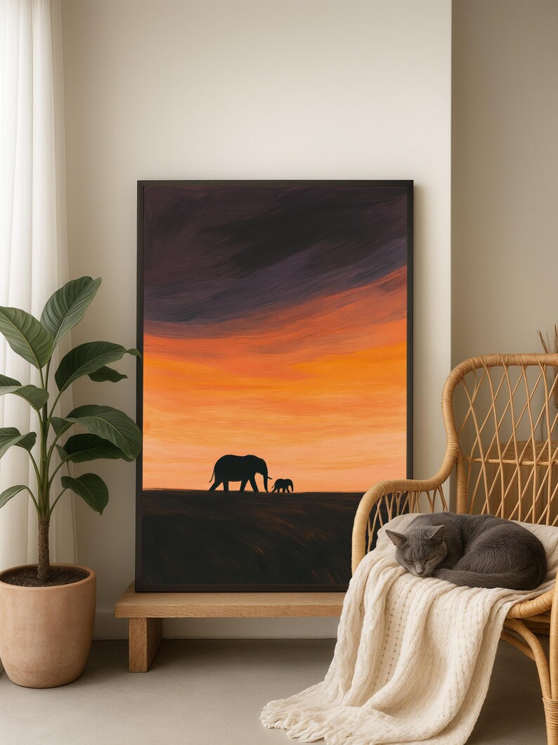 May include: A framed art print depicts a silhouette of two elephants against a vibrant sunset. The sky transitions from dark purple to fiery orange. The artwork is displayed on a wooden bench, next to a potted plant and a wicker chair.