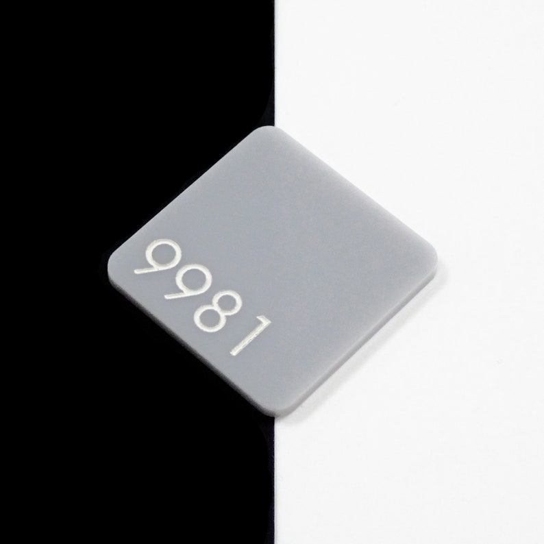May include: A gray square with the number 9981 printed on it in white.