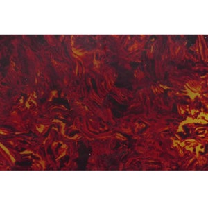 Puede incluir: Primer plano de una lámina de plástico rojo y dorado con vetas. La lámina tiene un patrón de remolino y un acabado brillante.