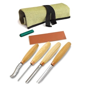 May include: A set of wood carving tools with wooden handles and metal blades. The set includes four chisels, a sharpening stone, a green sharpening compound, and a canvas tool roll with a black strap.