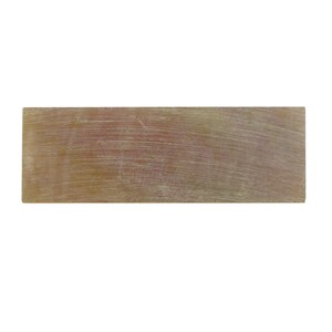 May include: A rectangular object with a metallic finish and a brushed texture. The surface shows linear patterns, possibly from a metal or composite material. The colour is a blend of gold and silver, with a slightly worn appearance.