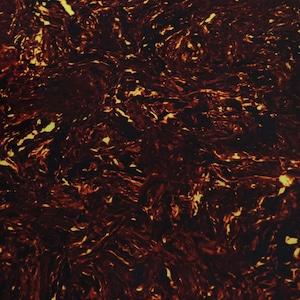 Puede incluir: Patrón abstracto con una base marrón oscuro y negro, superpuesto con remolinos de color naranja y amarillo fuego. El diseño se asemeja a lava fluyendo o un efecto veteado, creando una apariencia dinámica y texturizada.