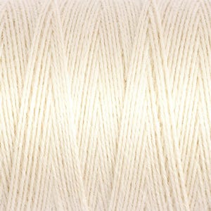 May include: Close-up of a spool of off-white yarn. The yarn is tightly wound, creating a textured surface with visible individual strands. The color is a soft, creamy white, suitable for various crafting projects.