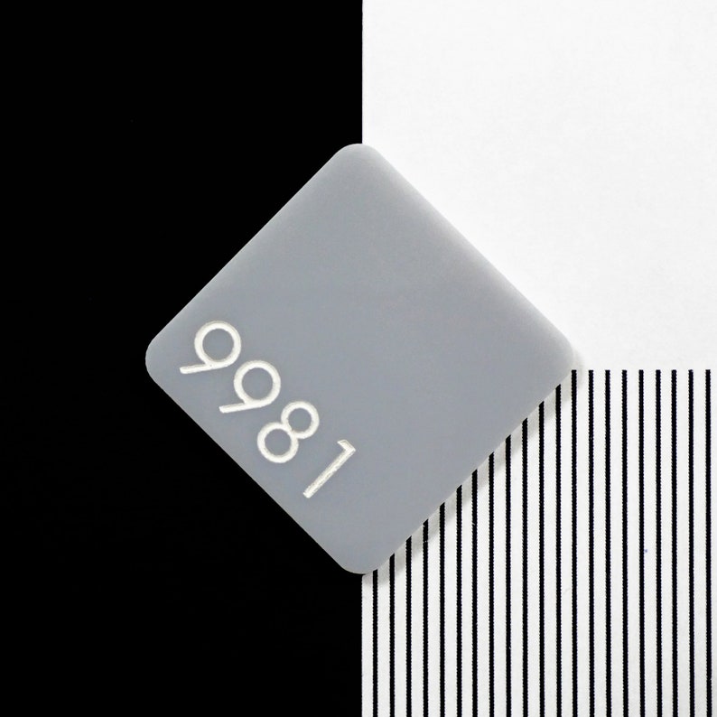 May include: A gray square with the number 9981 printed in white on it.