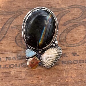 Labradorita brillante, concha de cardita de nervaduras anchas, larimar reciclado, concha de vieira forjada a mano en una mezcla de acero inoxidable y oro de 14 quilates; banda reticulada de 10 mm