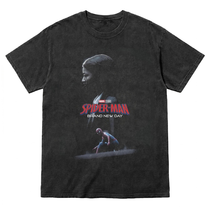 May include: Dark gray t-shirt featuring a graphic from the Marvel Studios Spider-Man movie. The design includes a silhouette of a person, the Spider-Man logo, and the text "Brand New Day".