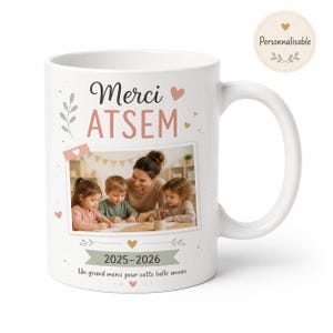 Peut inclure: Un mug en céramique blanc orné du texte Merci ATSEM, d'une photo d'un adulte et de deux enfants dessinant, des années 2025-2026, et du texte Un grand merci pour cette belle année, décoré de petits cœurs et de motifs de feuilles.