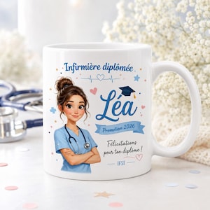 Op de afbeelding: Een witte keramische mok met een cartoonillustratie van een verpleegkundige met bruin haar in een knot, blauwe kleding en een stethoscoop. De tekst luidt Infirmière diplômée, Léa, Promotion 2026, Félicitations pour ton diplôme en IFSI.