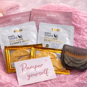 May include: A collection of beauty products, including face masks and eye patches, arranged on pink tissue paper. The products include "Snail Collagen Essence Mask" and "Bio-Collagen Real Deep Mask". A card reads "Pamper yourself".