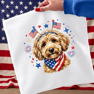 May include: A white square fabric with a patriotic dog illustration. The dog has brown fur, a blue headband with American flags, and a bandana with a star-spangled design. Red, white, and blue stars and fireworks surround the dog.