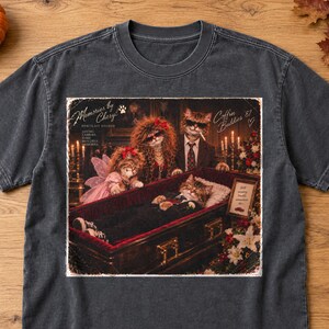 K&ouml;nnte beinhalten: Ein anthrazitfarbenes T-Shirt mit einem Grafikdruck von vier Katzen in einer Bestattungsszene. Der Text lautet Memories by Cheryl Portrait Studio, Loving Families Make Beautiful Memories und Coffin Buddies '87.