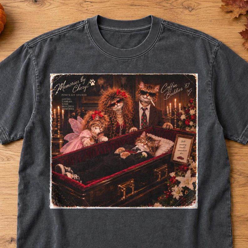 K&ouml;nnte beinhalten: Ein anthrazitfarbenes T-Shirt mit einem Grafikdruck von vier Katzen in einer Bestattungsszene. Der Text lautet Memories by Cheryl Portrait Studio, Loving Families Make Beautiful Memories und Coffin Buddies '87.