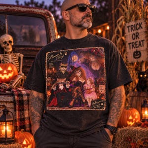 Pu&ograve; includere: Una t-shirt grigio antracite con una stampa grafica di una famiglia di gatti in costume di Halloween. Il testo recita Memories by Cheryl, Portrait Studio, e Halloween 87, Some Family, More Magic, con un cartello Trick or Treat vicino.