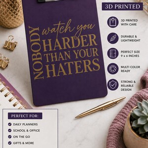 May include: A 9 x 6 inch purple 3D printed clipboard featuring a silver metal clip at the top. The surface displays gold text that reads: Nobody watch you harder than your haters. The clipboard is presented with informational icons and text.