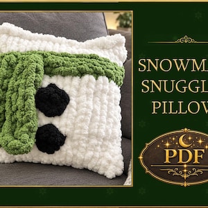 May include: A white crocheted cushion featuring a thick green scarf draped across the top and two black circular accents below. The text SNOWMAN SNUGGLES PILLOW and PDF are displayed on the right side of the image in gold lettering.