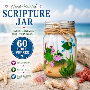 Op de afbeelding: Een handbeschilderde Schriftpot met een zilveren deksel, gevuld met bijbelverzen. De pot is versierd met geschilderde zeeschildpadden en zeewier. De tekst op de pot luidt "Scripture Jar" en "Encouragement for Every Season". De pot is omgeven door schelpen en een zeester.