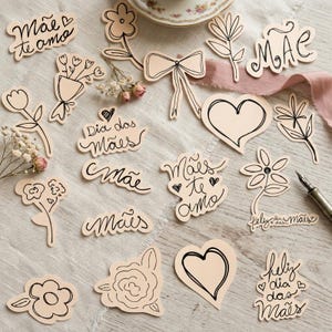 May include: A collection of light pink paper cutouts with black outlines, featuring floral designs, hearts, and handwritten text. The text includes phrases like "Mãe te amo" and "Dia das Mães". A pen and a teacup are also visible.