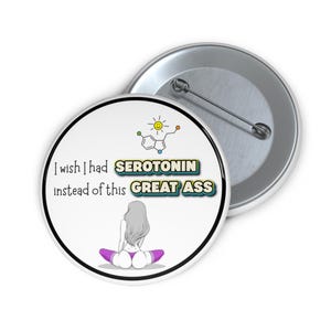 May include: A white button featuring the text "I wish I had SEROTONIN instead of this GREAT ASS." The design includes a serotonin molecule, a sun, and a seated figure. The button is round with a metal pin back.