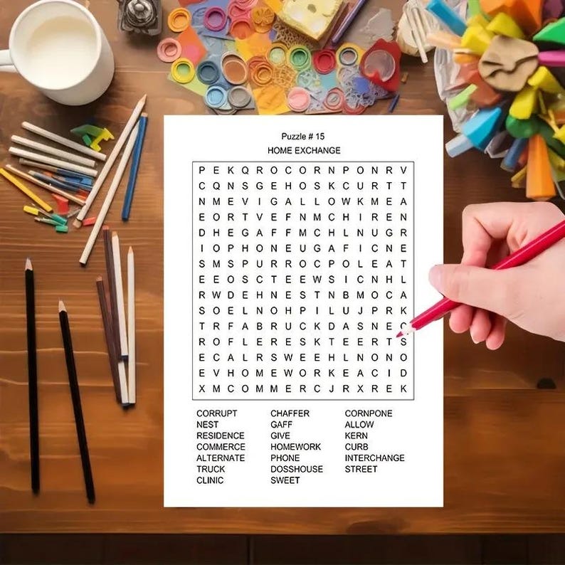 K&ouml;nnte beinhalten: Ein wei&szlig;es Blatt Papier mit einem Wortsuchr&auml;tsel mit dem Titel Puzzle # 15 HOME EXCHANGE, das ein Buchstabenraster und eine Liste der zu suchenden W&ouml;rter enth&auml;lt. Ein roter Stift liegt auf dem Raster, umgeben von verschiedenen Buntstiften.
