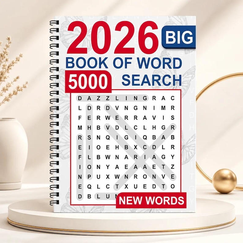 K&ouml;nnte beinhalten: Ein spiralgebundenes 2026 Big Book of Word Search 5000 mit wei&szlig;em Einband, dezentem Schmetterlingsmuster, rotem und blauem Text sowie einem zentralen Buchstabenr&auml;tsel mit markierten W&ouml;rtern. Unten rechts befindet sich ein rotes New Words Etikett.