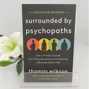May include: A black book titled Surrounded by Psychopaths by Thomas Erikson, featuring four colorful circles with silhouettes of people. The cover includes the subtitle How to Protect Yourself from Being Manipulated and Exploited in Business.