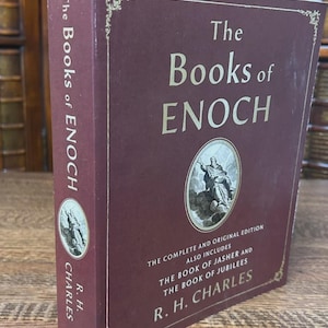 K&ouml;nnte beinhalten: Ein Hardcover-Buch mit dem Titel "The Books of Enoch" in Burgunderrot. Das Buch enth&auml;lt "The Complete and Original Edition" und "The Book of Jasher and The Book of Jubilees". Der Name des Autors, R. H. Charles, ist ebenfalls sichtbar.