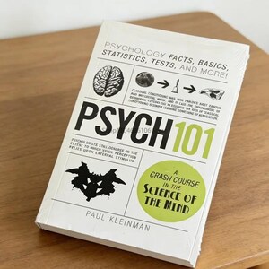 May include: A white paperback book titled Psych 101: Psychology Facts, Basics, Statistics, Tests, and More! by Paul Kleinman. The cover features a brain illustration, a Rorschach inkblot, and a green circle with the text A Crash Course in the Science of the Mind.