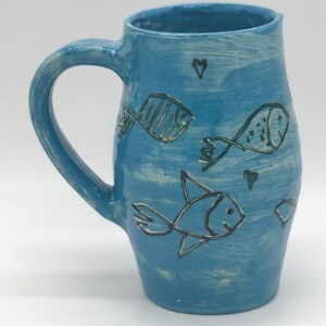 Hand-Carved School of Fish Swimming on a turquoise mug