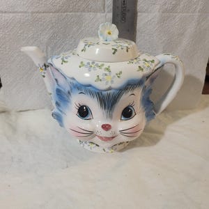 May include: A set of three ceramic mugs with a speckled, matte finish. Each mug is a different colour: light blue, cream, and grey. The mugs have a simple, modern design and a comfortable handle.