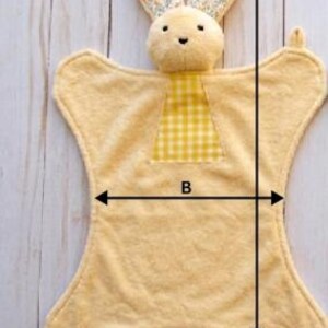 May include: A yellow bunny-shaped security blanket with floral patterned ears and a yellow gingham patch. The blanket measures 21.65 inches (55 cm) long and 11.81 inches (30 cm) wide. The text "Yellow Bunny" is visible.