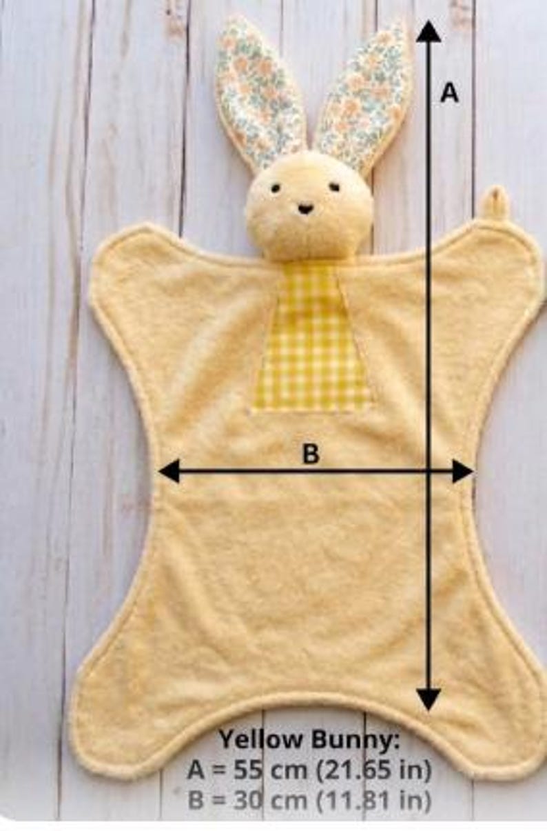 May include: A yellow bunny-shaped security blanket with floral patterned ears and a yellow gingham patch. The blanket measures 21.65 inches (55 cm) long and 11.81 inches (30 cm) wide. The text "Yellow Bunny" is visible.
