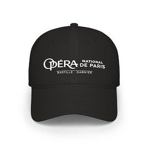 Pode incluir: Um boné de beisebol preto com texto bordado em branco que diz Opéra National de Paris, com Bastille e Garnier impressos abaixo. O boné possui uma copa estruturada, aba curva e um botão no topo, apresentando um design limpo e simples.