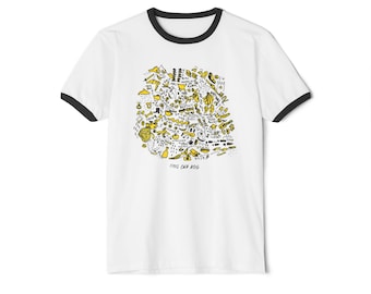 Op de afbeelding: Een wit ringer-t-shirt met zwarte boorden bij de kraag en mouwen. De voorkant heeft een dichte, handgetekende afbeelding in zwarte en gele inkt, met diverse kleine krabbels en de tekst "THIS OLD DOG" onderaan op het shirt gedrukt.