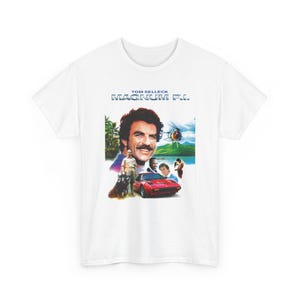 Könnte beinhalten: Ein weißes Kurzarm-T-Shirt mit einem Grafikdruck der Fernsehserie Magnum P.I. Das Design zeigt ein Porträt von Tom Selleck, einen roten Sportwagen, einen Hubschrauber und weitere Darsteller vor einer tropischen Inselkulisse.
