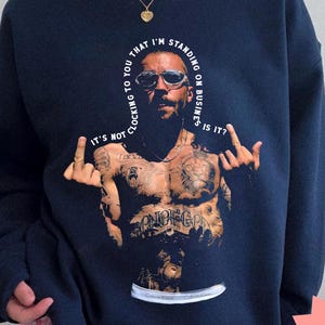 May include: Navy blue sweatshirt featuring a graphic of a man with tattoos and sunglasses. The text on the sweatshirt says, "It's not locking to you that I'm standing on business, is it?" The words "ABA THERAPIST TEACHER SWEATSHIRT" are also printed on the sweatshirt.