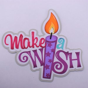 Könnte beinhalten: Ein farbenfrohes Stanzdesign mit einer Kerze mit einer orangefarbenen und gelben Flamme. Die Kerze ist lila mit Sternen. Die Worte "Make a Wish" sind in einer verspielten Schriftart mit rosa und lila Farbtönen geschrieben.