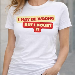 May include: White t-shirt with the text "I MAY BE WRONG BUT I DOUBT IT" in yellow and red. The shirt is being worn by a person in blue jeans.