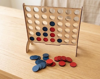 May include: Wooden Connect Four game with a natural wood finish. The game board has a grid of holes, with red and blue game pieces scattered below. The game is set on a light-coloured wooden table, ready for play.