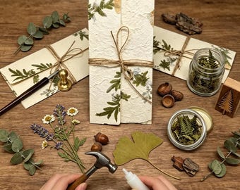 Bröllopskuvert i pressat blompapper och inbjudningar med växtmotiv och återvunnet solrosmotiv