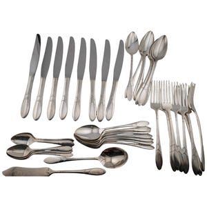 May include: A silver-toned stainless steel cutlery set comprising eight dinner knives, four dinner forks, four salad forks, four soup spoons, four teaspoons, and one butter knife. Each piece features a smooth handle with a subtle etched leaf design.