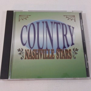 Puede incluir: Una caja de CD con fondo verde y un óvalo azul con el texto "COUNTRY NASHVILLE STARS" en blanco.