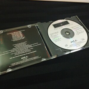 May include: A compact disc case, open to reveal a silver CD with the text "The Country Music Hall of Fame" and "The Carter Family." The case is clear plastic, with a black interior. The CD is labeled with the MCA logo.