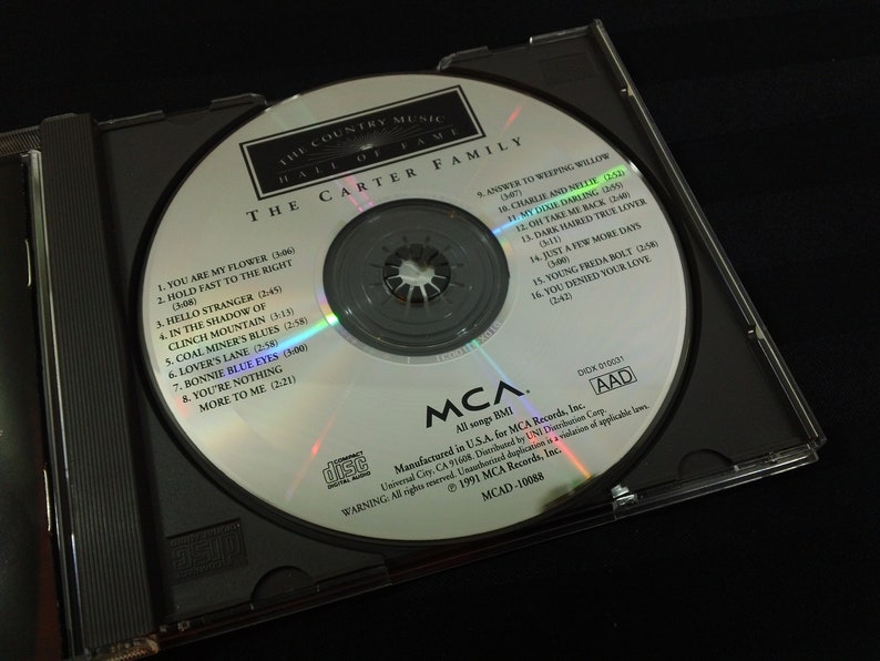 May include: A compact disc from The Carter Family, featuring the album "The Country Music Hall of Fame." The silver disc is in a black jewel case. The disc has song titles like "Bonnie Blue Eyes" and "My Dixie Darling."