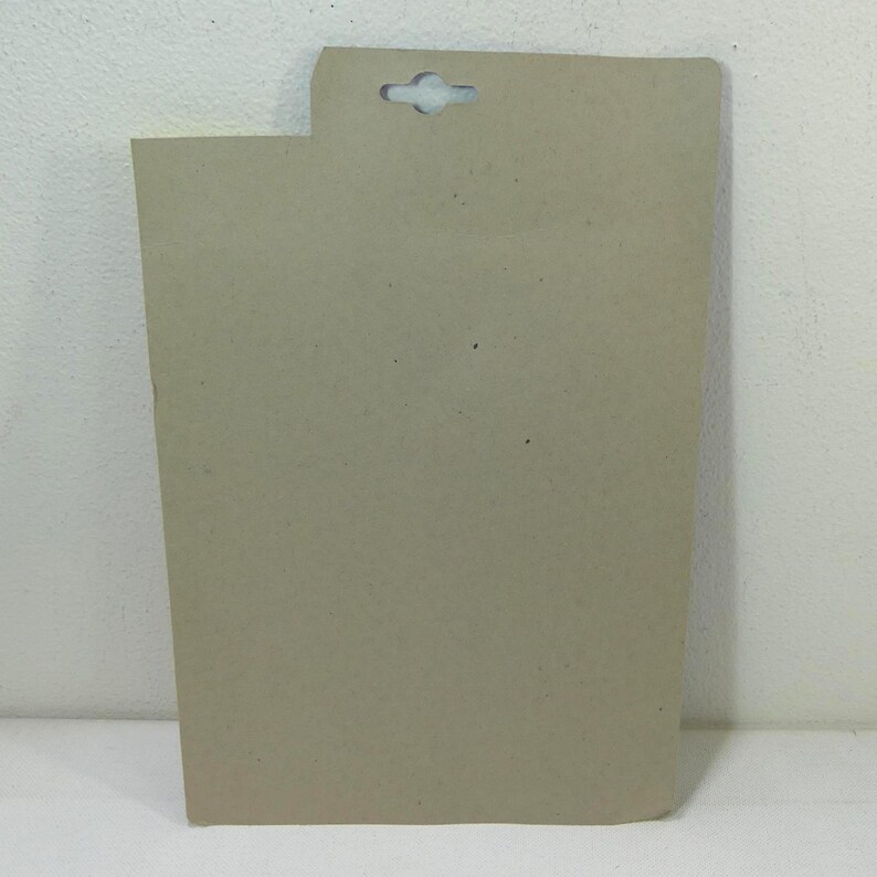 May include: A plain brown cardboard backing card with a hole punched in the top for hanging.